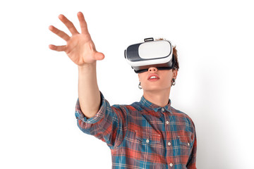 Teenager in virtual reality headset studio standing isolated on white touching empty space close-up