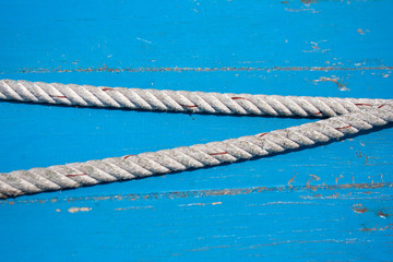 Boat cable detail on cyan painted wooden plank background