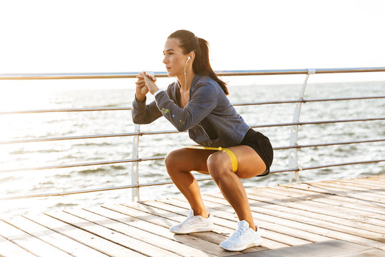 Concentrated sportswoman doing exercises with a rubber band