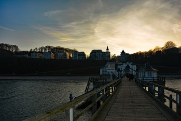 Fototapeta na wymiar Auf dem hinteren Holzsteg der Historischen Seebrücke in Sellin auf Rügen in Deutschland, bei Sonnenuntergang
