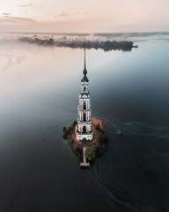 Aerial view of abandoned belfry on the lonely island on the Volga river. Russia. Kalyazin. Russian churches.