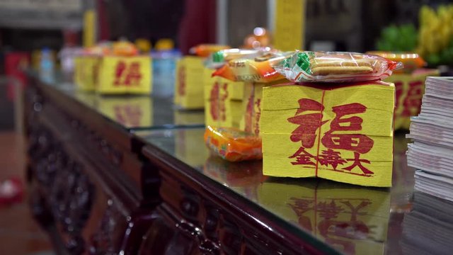 4k, People offerings food and joss paper in templo of Tainan Grand Matsu Temple. Kanjin is a large paper squares with golden metallic rectangle, burned for gods and spirits or ancestors in Taiwan-Dan
