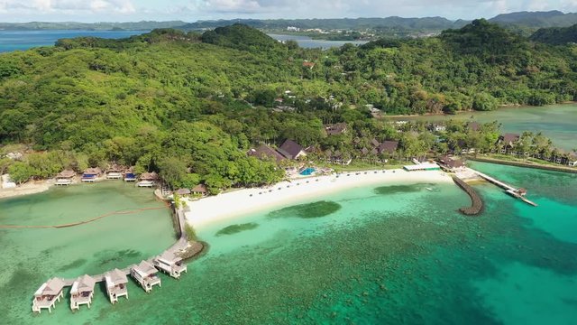Aerial view of white sand beach in tropical paradise of Meyuns, turquoise crystal clear waters of Pacific Ocean, lush green vegetation - landscape panorama of Micronesia from above, Palau, Koror