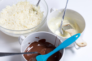 Ingredients for dessert are on the table. Cooking sweets with coconut and condensed milk. In a glaze of white and black chocolate.