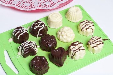 Cooking sweets with coconut and condensed milk. In a glaze of white and black chocolate.