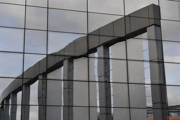 Fototapeta premium A reflection of a building with three columns.