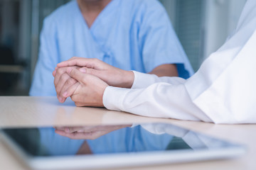 Woman doctor holds hands for male patients to encourage.