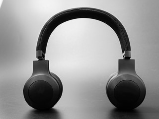 wireless black headphones on a dark background.