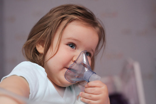 Smiling little girl with asthma inhaler.