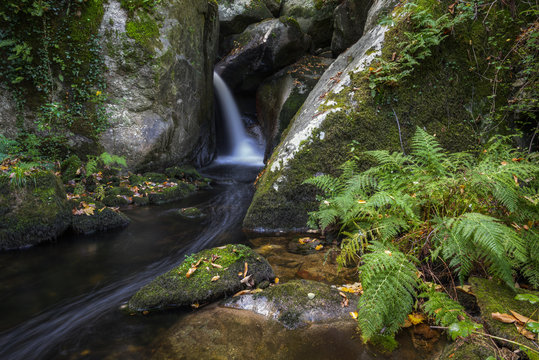 A stream jumps and forms cascades between granite rocks