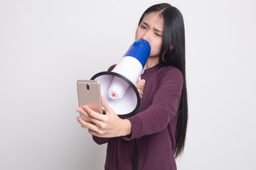 Obraz premium Angry young Asian woman shout with megaphone to mobile phone.
