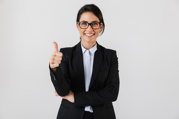 Portrait of caucasian businesswoman 30s in formal wear and eyeglasses standing in the office, isolated over white background