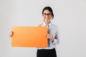 Image of pleased office woman wearing eyeglasses holding yellow copyspace placard, isolated over...