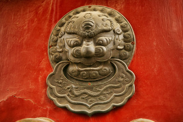 Richly decorated red wooden door with decoration in the Forbidden City, Beijing, China. 