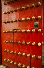 Richly decorated red wooden door with decoration in the Forbidden City, Beijing, China. 