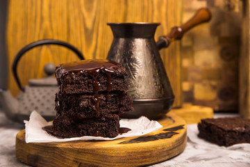 Dessert with cocoa brownies in chocolate near tea pot and coffee turk
