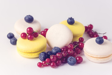 French Colorful Macarons White and Yellow Macarons on Blue Background with Fresh Red Currant Copy Space Horizontal French Dessert Toned
