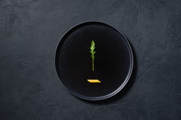 The concept of pasta Penne with arugula, minimalism. Dark background, top view, space for text