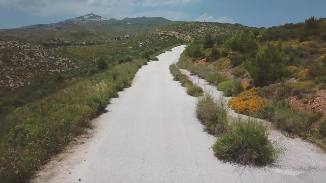 Forward drone shot over a motorcyclist passing under the camera during a summer afternoon. 4k drone quality
