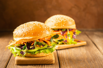 Veggie burger with fresh raw vegetables on a dark wooden background. Healthy eating concept. Copy space.