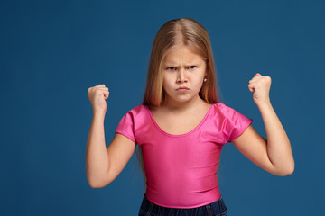 Fototapeta premium Portrait of emotional little girl on blue background