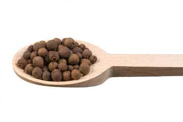 allspice on wooden spoon isolated on white background