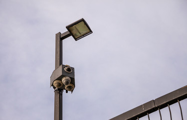 Outdoor security cameras and lights isolated against the sky