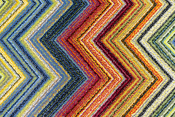 Obraz premium The texture of the carpet with bright multi-colored zigzags.