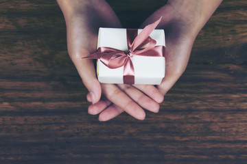 Gift Box in Women's Hand It's a gift box for your loved ones. - obrazy, fototapety, plakaty