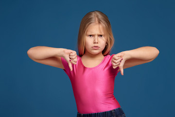 Portrait of emotional expressive little girl on blue background