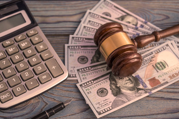 the judge's gavel, calculator, banknotes of American dollars on the background of wooden table. business, Finance, corruption.