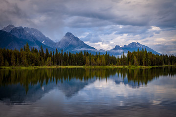 Fototapeta na wymiar Mountains reflecting in the calm waters of Spillway Lake in Peter Lougheed Provincial Park, Alberta, Canada