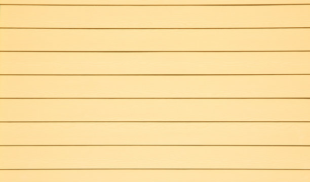 A simple background of bright yellow exterior siding on a house.