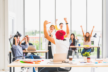 Multiethnic diverse group of creative team or business coworker celebrate together in modern office. Success teamwork or startup company concept