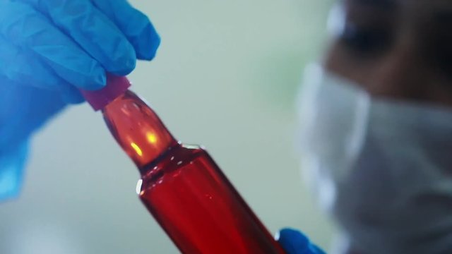 A biodiesel scientist inspecting a bottle of purified macauba palm oil. The sustainable fuel.