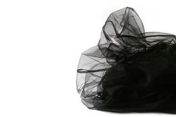 Abstract composition of black tulle material  isolated on white background. Waving shape of tulle...