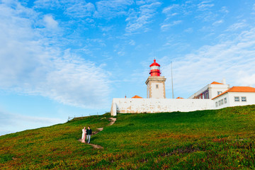 Fototapeta na wymiar beautiful lighthouse. the couple in love walking on the path nea