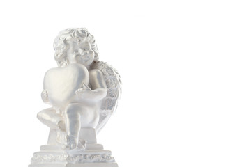 Fototapeta premium Cherub statue isolated on white background. Angel holds the heart. Love