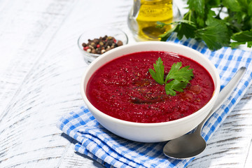 cold beet soup in a bowl on white background