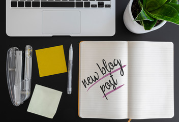 words new blog post written on note pad on desk next to laptop and adhesive notes