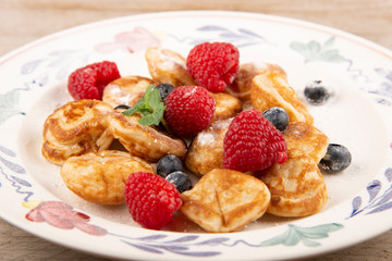 Pancakes, poffertjes with blueberries, raspberries and sugar