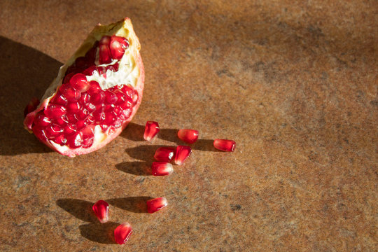 Ripe red granet or pomegranate. Fruits of red ripe pomegranate on marble brown. Organic and healthy pomegranate fruit. Open Pomegranate.