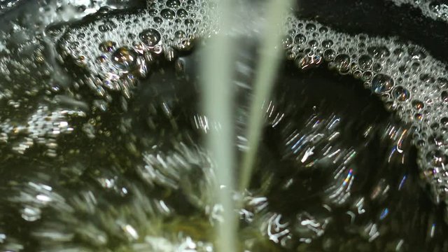 Sustainable biodiesel macauba palm oil, being poured into a commercial container.