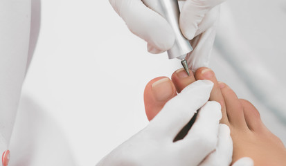 Chiropodist verwijdert de nagelriem op de nagels met behulp van hardware. Pedicureservice