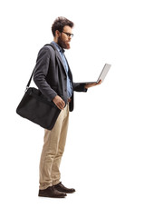 Man standing with a shoulder bag and holding a laptop