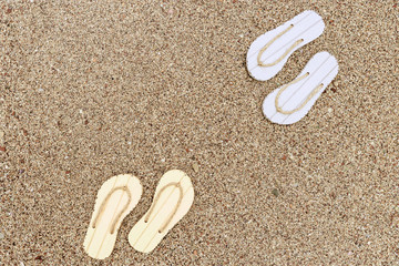 Summer shoes on the sand. Beach flip flops. Summer background. Copy space.