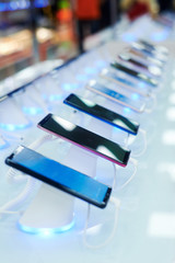 row of many smartphones is on sale at showcase in store