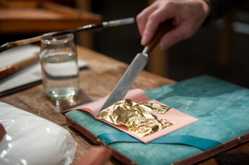 Craftsman cuts an extremely thin gold leave for the gilding tecnique.