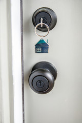 A Key with a House Keychain in the lock of a Front Door of a New Construction Home