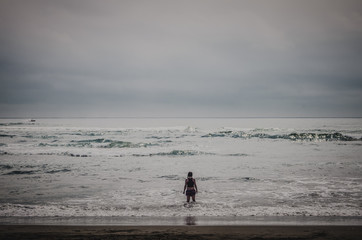 Fototapeta na wymiar Single woman looks at the pacific ocean.